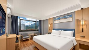 A hotel room with a large bed, a desk, a chair, a small table, and a view of a cityscape through the window. - Super 8 Hotel (Sanming Sanyuan Chengguan Furong Road) (Sanming)