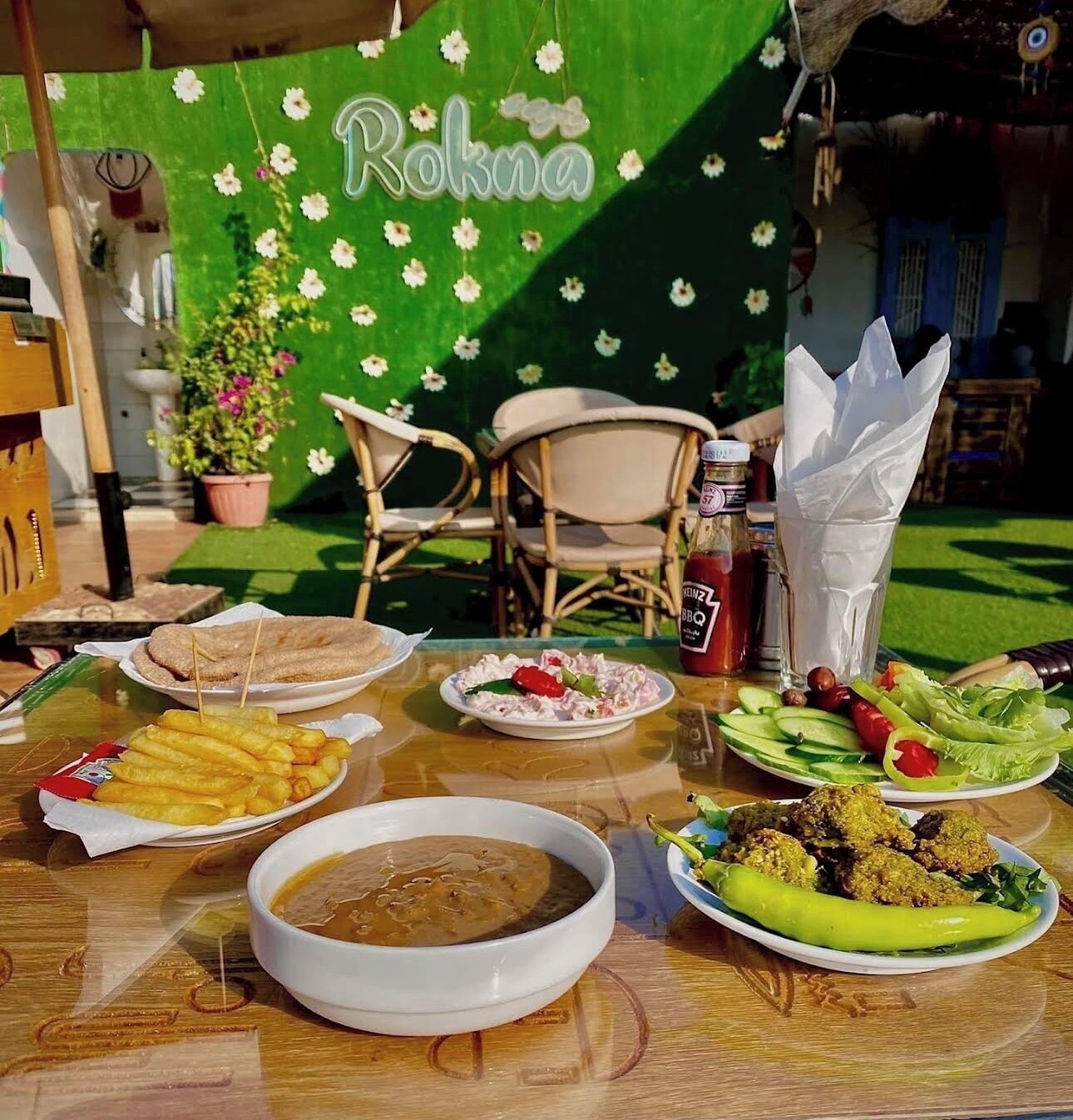 A table set with various dishes including fried items, a bowl of soup, and a plate with vegetables.