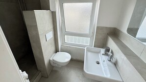 A compact bathroom with a toilet, sink, and shower. - City Apartment - Business, Uni, Handwerker - Free Wifi (Bochum)