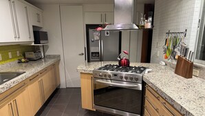 A modern kitchen with a stainless steel stove, oven, and refrigerator. - Quite and tasteful condo in Polanco, Mexico City (Ciudad de México)