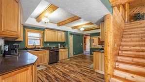 Una cocina amplia con armarios de madera, una isla central y vista a otra habitación.