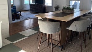 A spacious kitchen with a large island, bar stools, and a hanging pendant light.