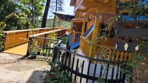 Eine Holzhütte mit Balkon und einem Schild, auf dem 'Flia. Hili' steht.