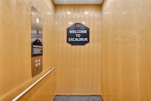 An elevator with a sign indicating 'Welcome to Excalibur' and a floor level indicator. - Excalibur: Pickleball, Duck Pin Bowling, Indoor Pool, 9 Hole Golf (Sevierville)