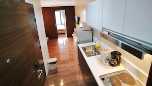 A modern kitchen with a stainless steel sink, a coffee machine, and a microwave. - Air Residences-CBD view  (Makati)