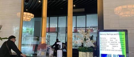 A reception area with a marble counter, large windows, and a sign about balcony railings and fittings.