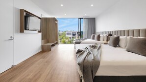 A modern hotel room with a large bed, a TV mounted on the wall, and a balcony with a city view. - Rambla @ Story House (Kangaroo Point)