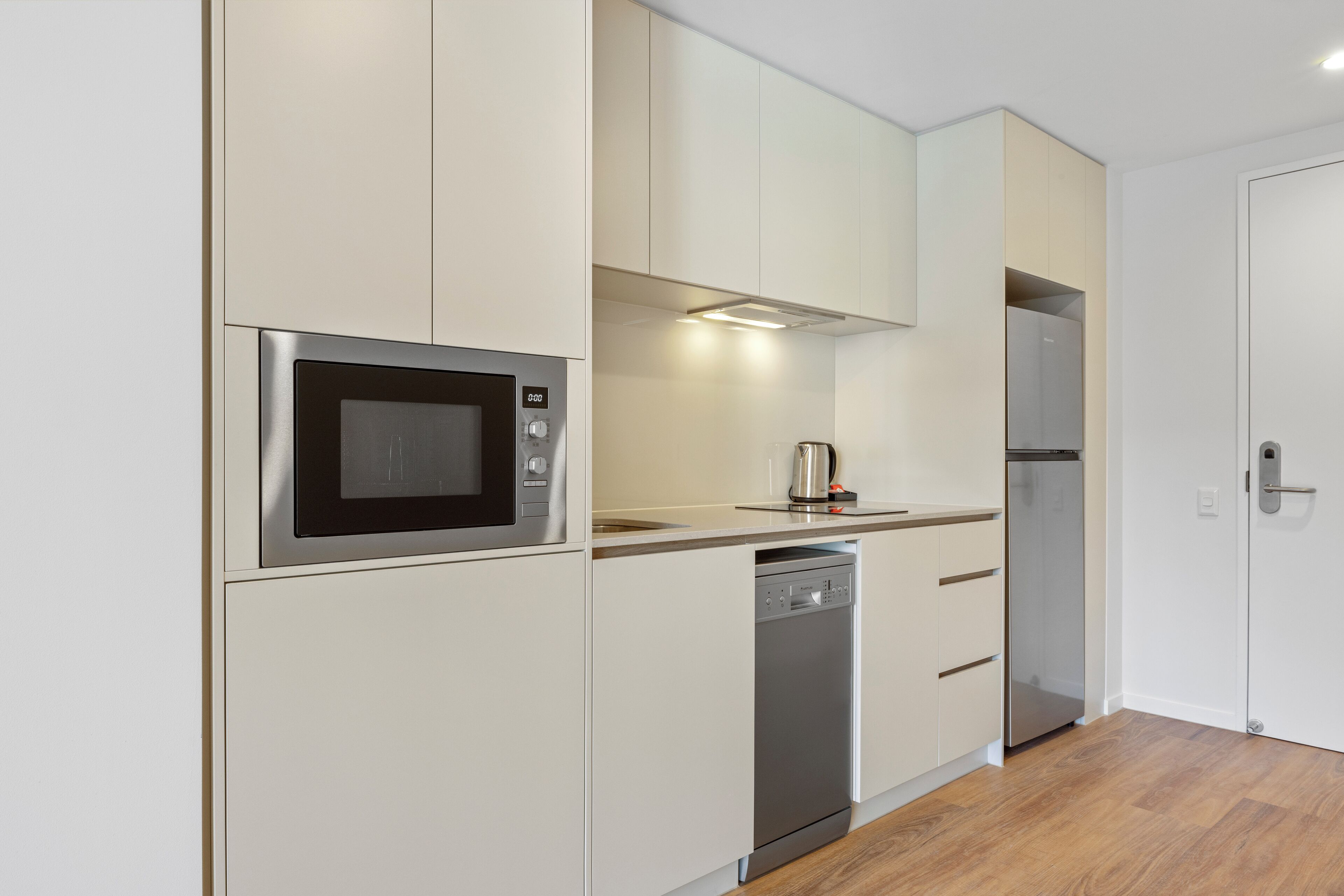 A modern kitchen with a built-in microwave, dishwasher, and refrigerator.