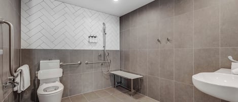 A modern bathroom with a toilet, shower, and sink.