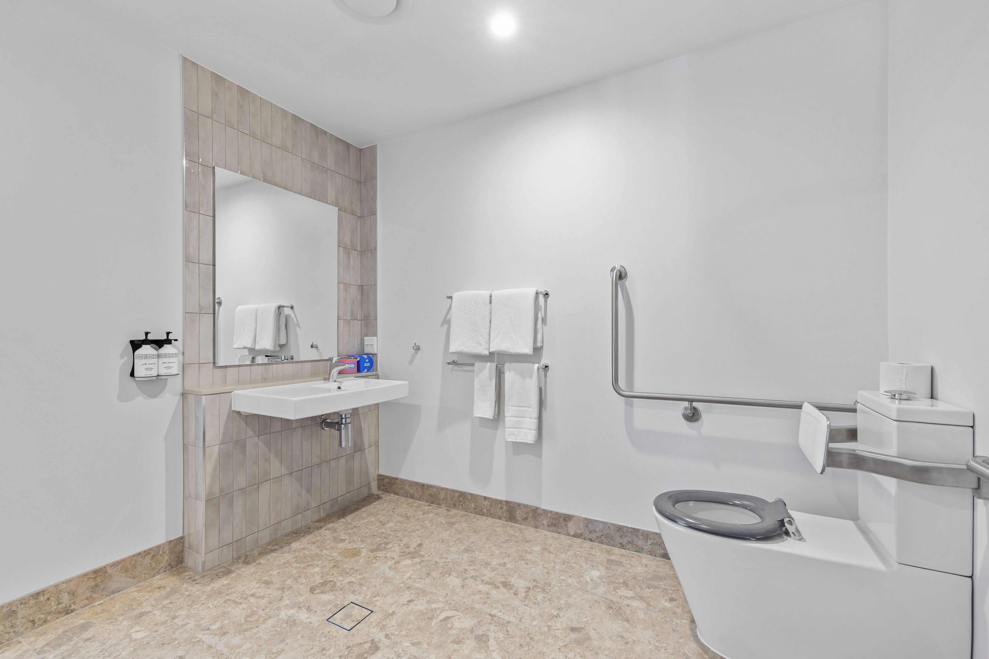 Een moderne badkamer met een wastafel, spiegel en toilet.
