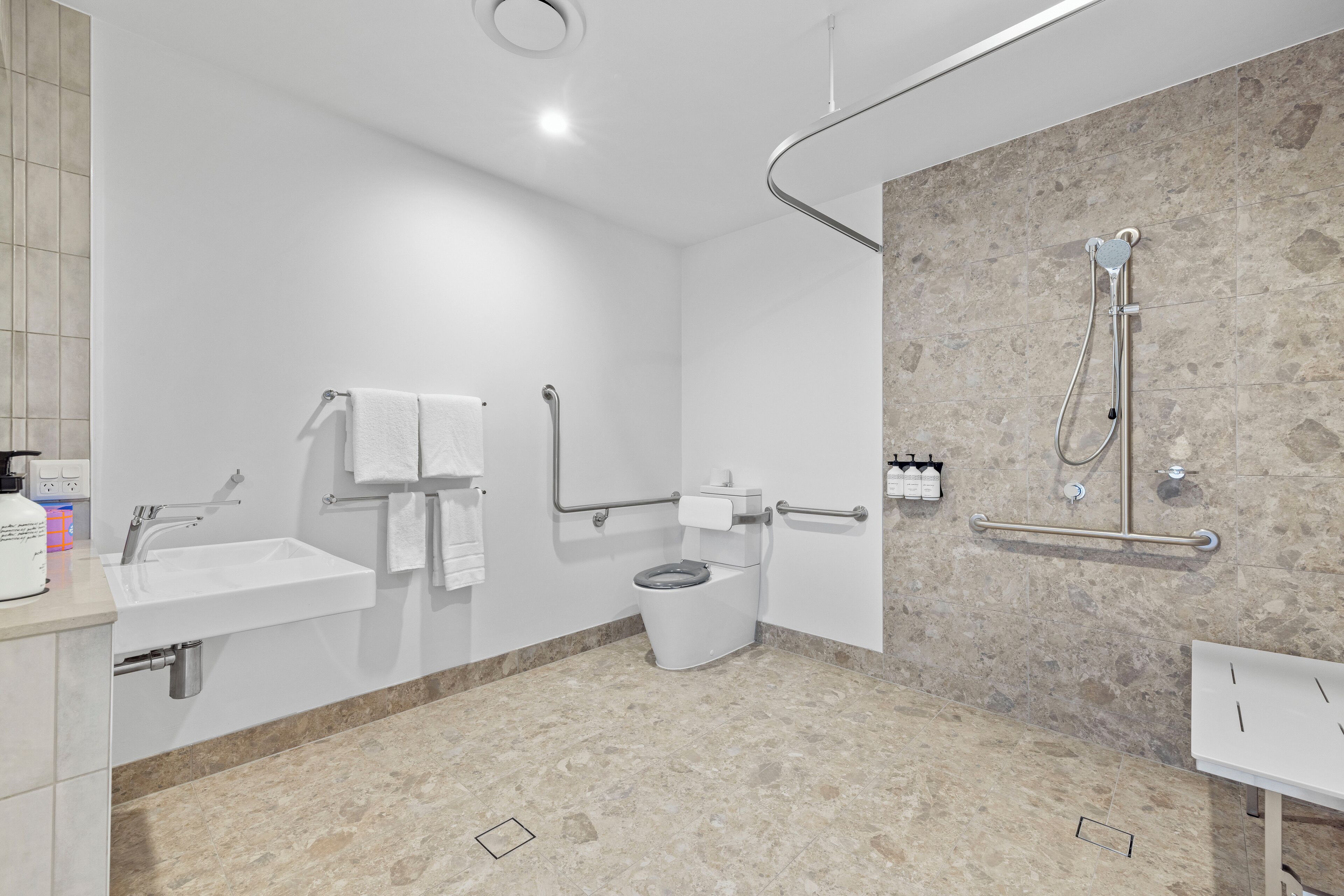 A modern bathroom with a sink, toilet, and shower.