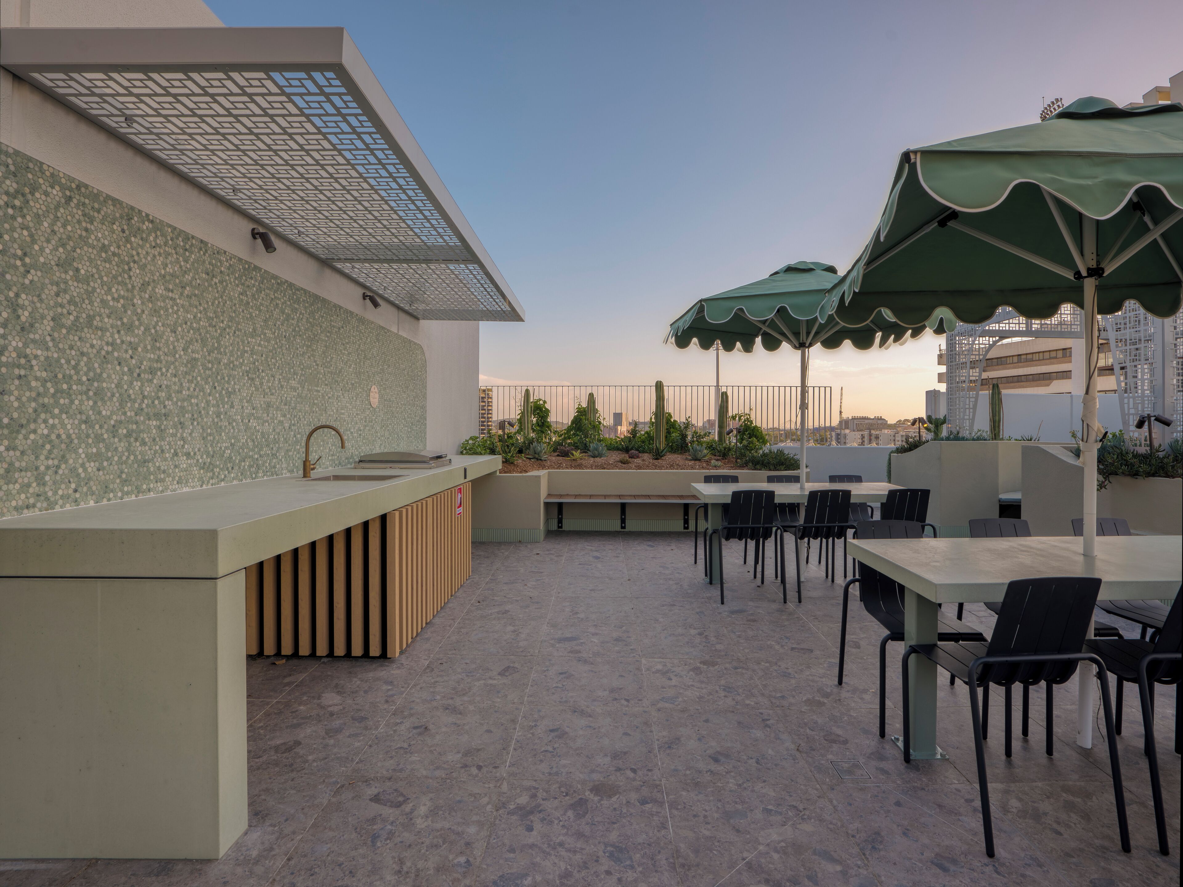 An outdoor patio area with a bar, seating, and umbrellas.