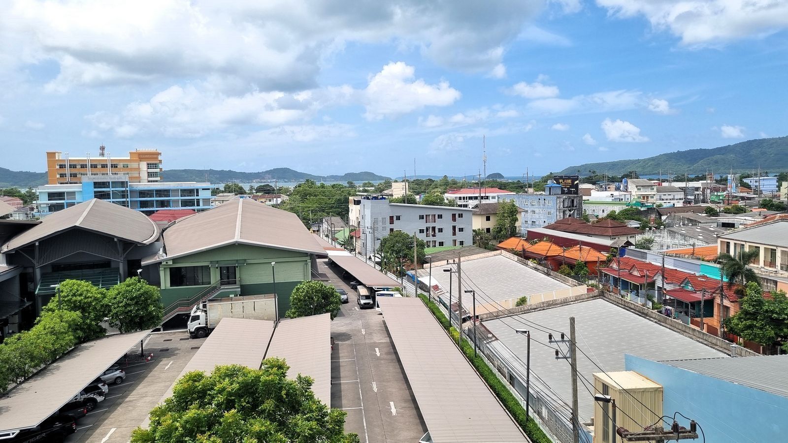 Uma área comercial com diversos edifícios, incluindo uma grande construção com vários andares e lojas menores.