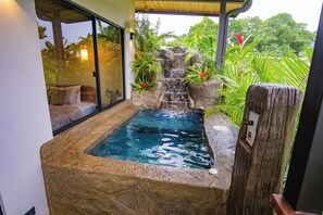 A spa area with a hot tub, a waterfall feature, and lush greenery. - Cozy villa with Jacuzzi and Ice bath, min from La Fortuna's main park. (Alajuela Province)