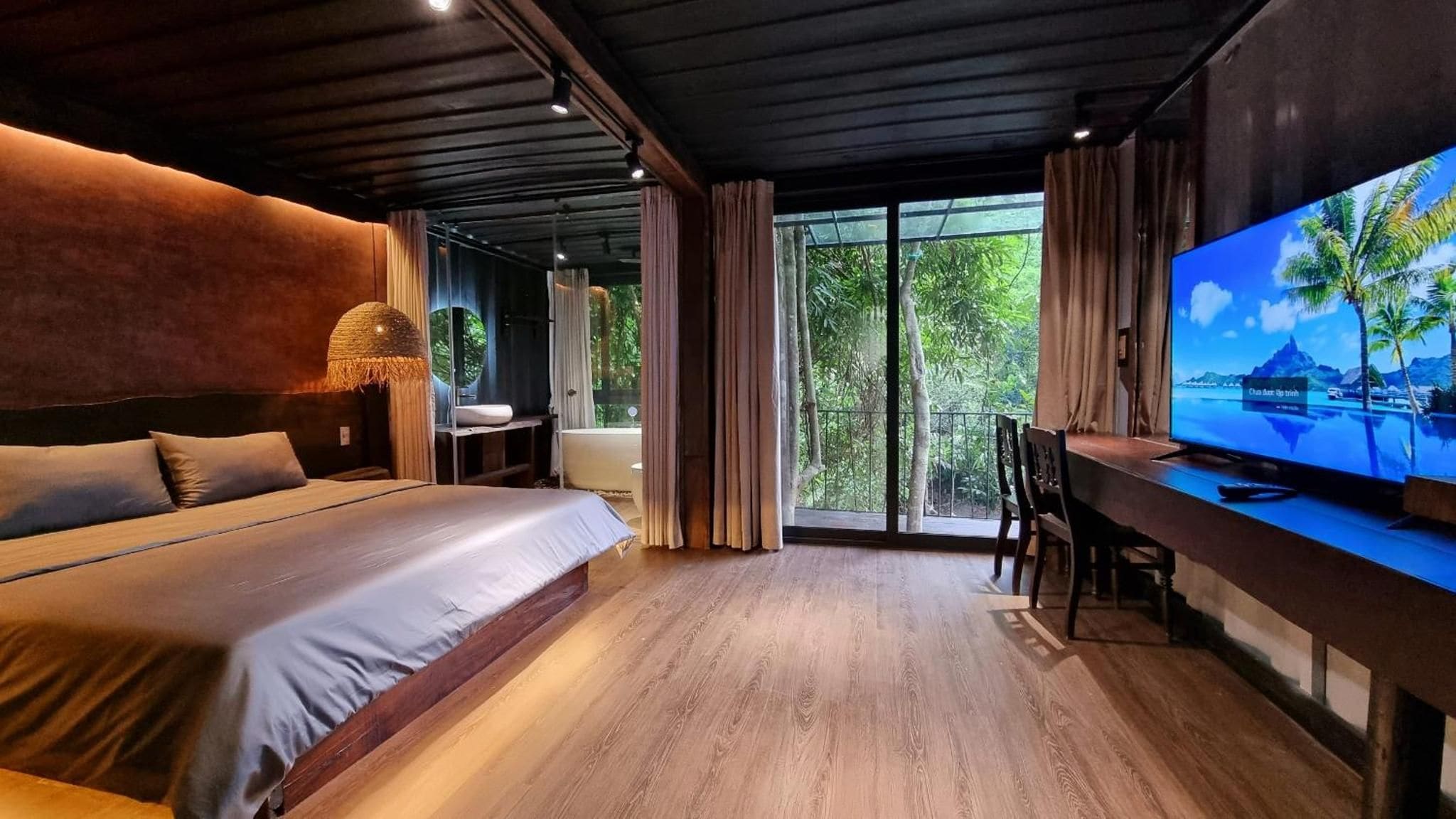 Un dormitorio moderno con una cama grande, un escritorio y un televisor.