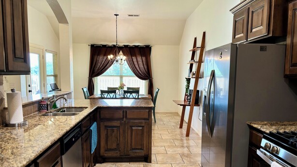 A kitchen with granite countertops, wooden cabinets, a stainless steel refrigerator, and a built-in oven. - Beautiful Cozy Edmond Home - 4bed 2bath (Edmond)