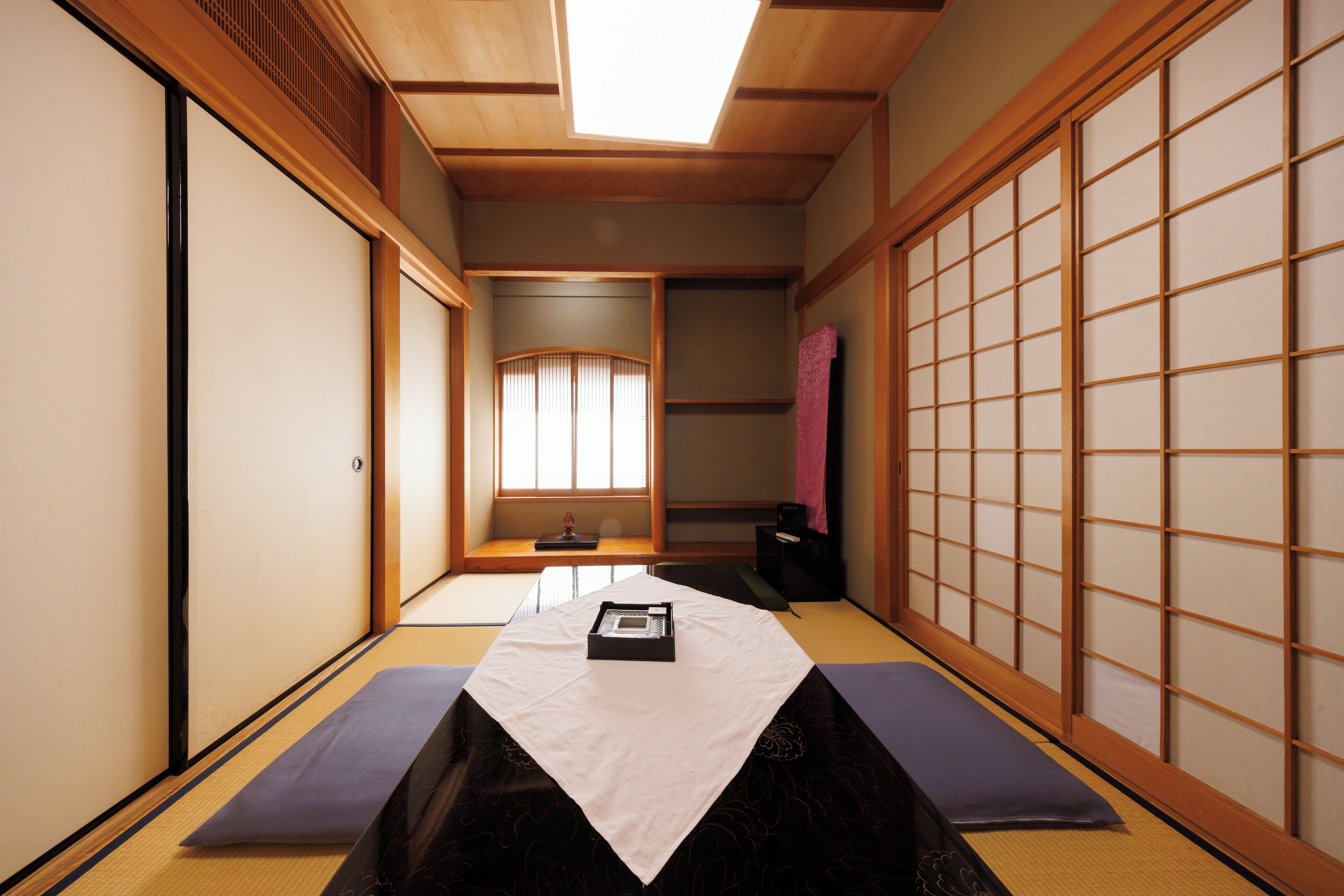 Een traditionele Japanse kamer met tatami vloerbedekking, schuifdeuren en een shoji scherm.