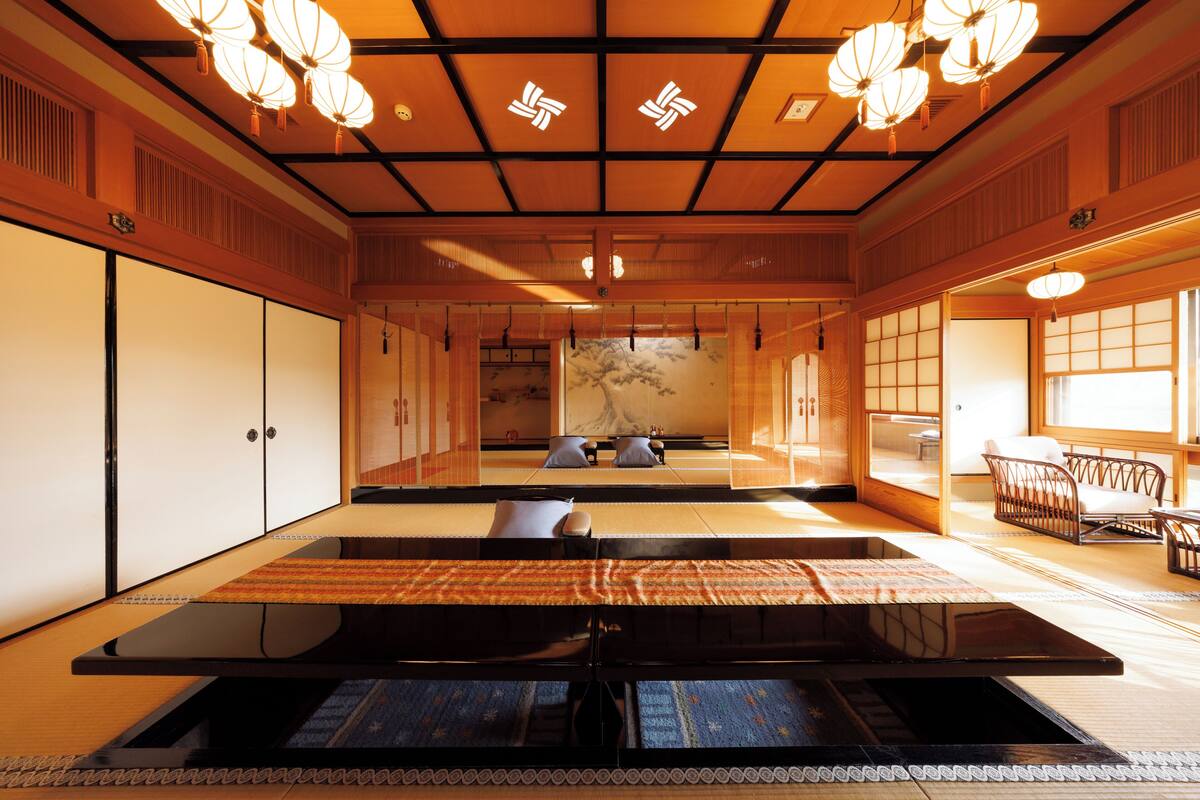 A traditional Japanese room with tatami flooring, a low table, and sliding doors.