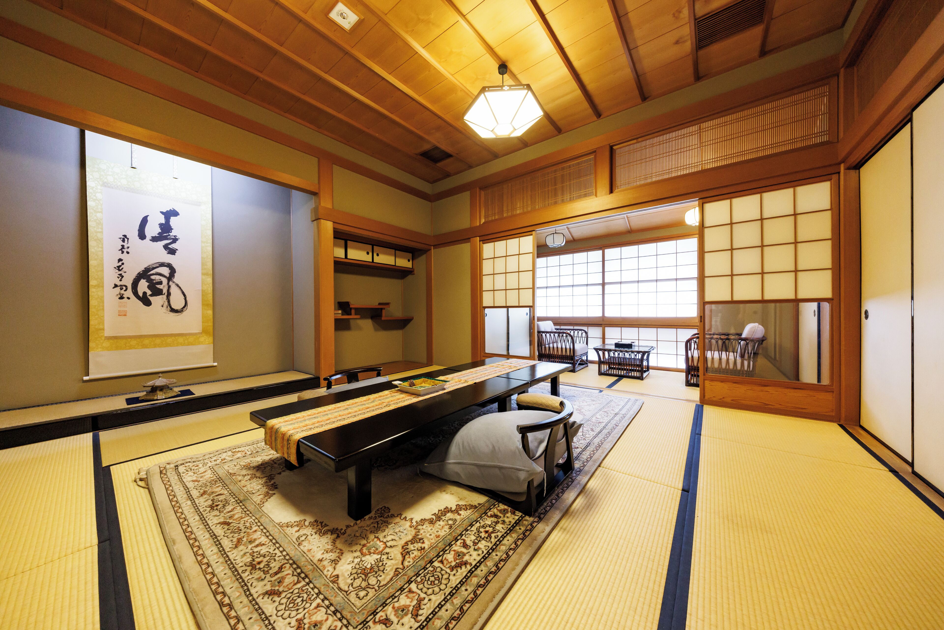 Um quarto japonês tradicional com tatames, uma mesa baixa e um portas correderas.