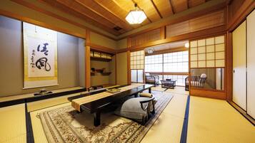 Um quarto japonês tradicional com tatames, uma mesa baixa e um portas correderas.