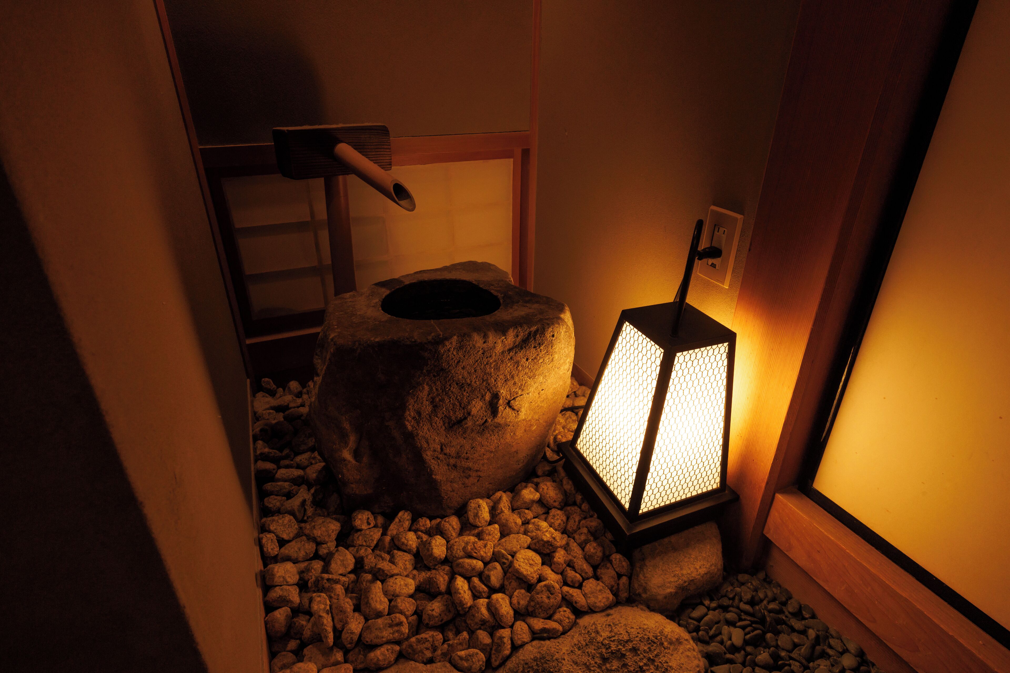 A stone lantern in a dimly lit room with a wooden ladder and a small window.