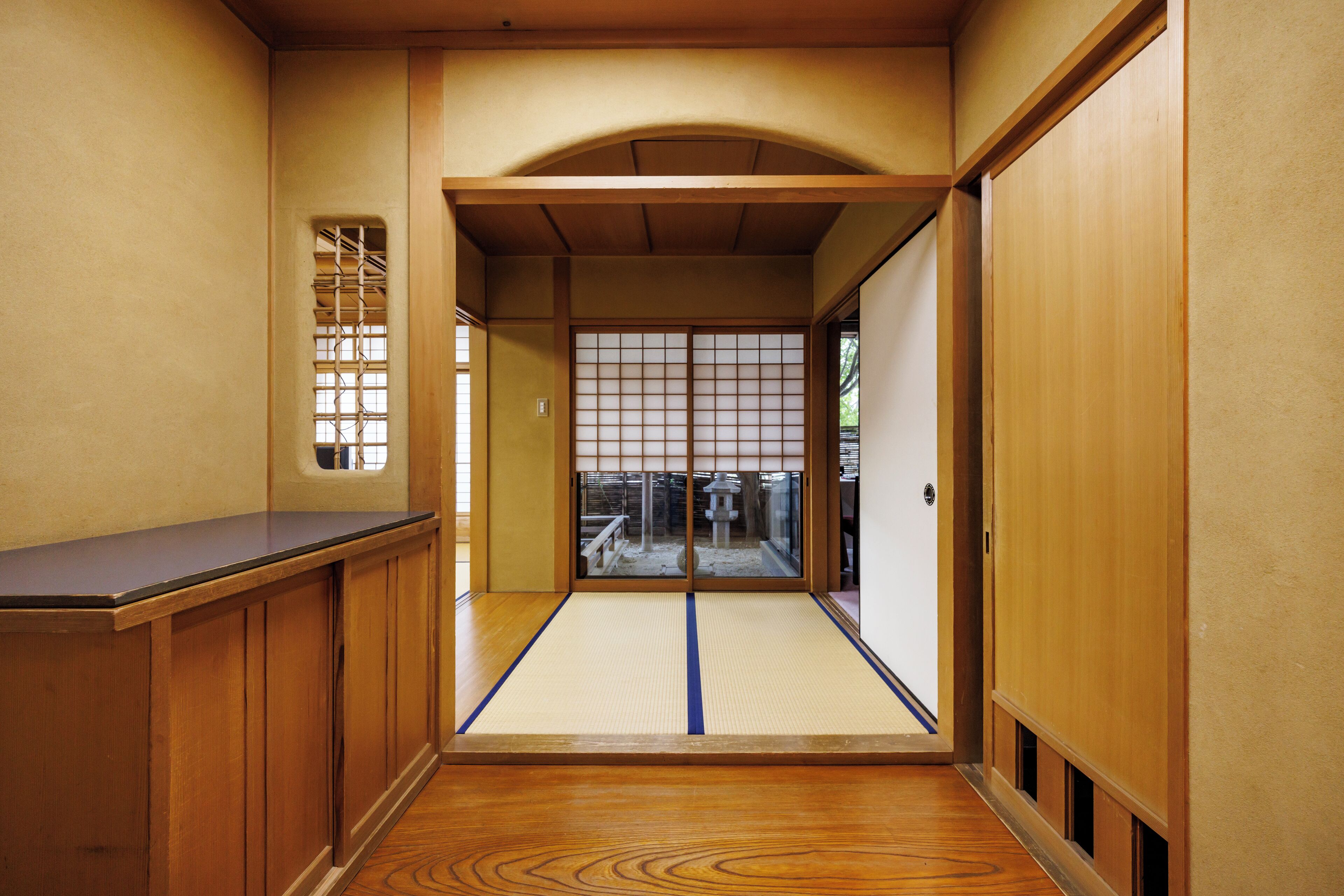 A traditional Japanese interior with tatami flooring, sliding doors, and wooden paneling.