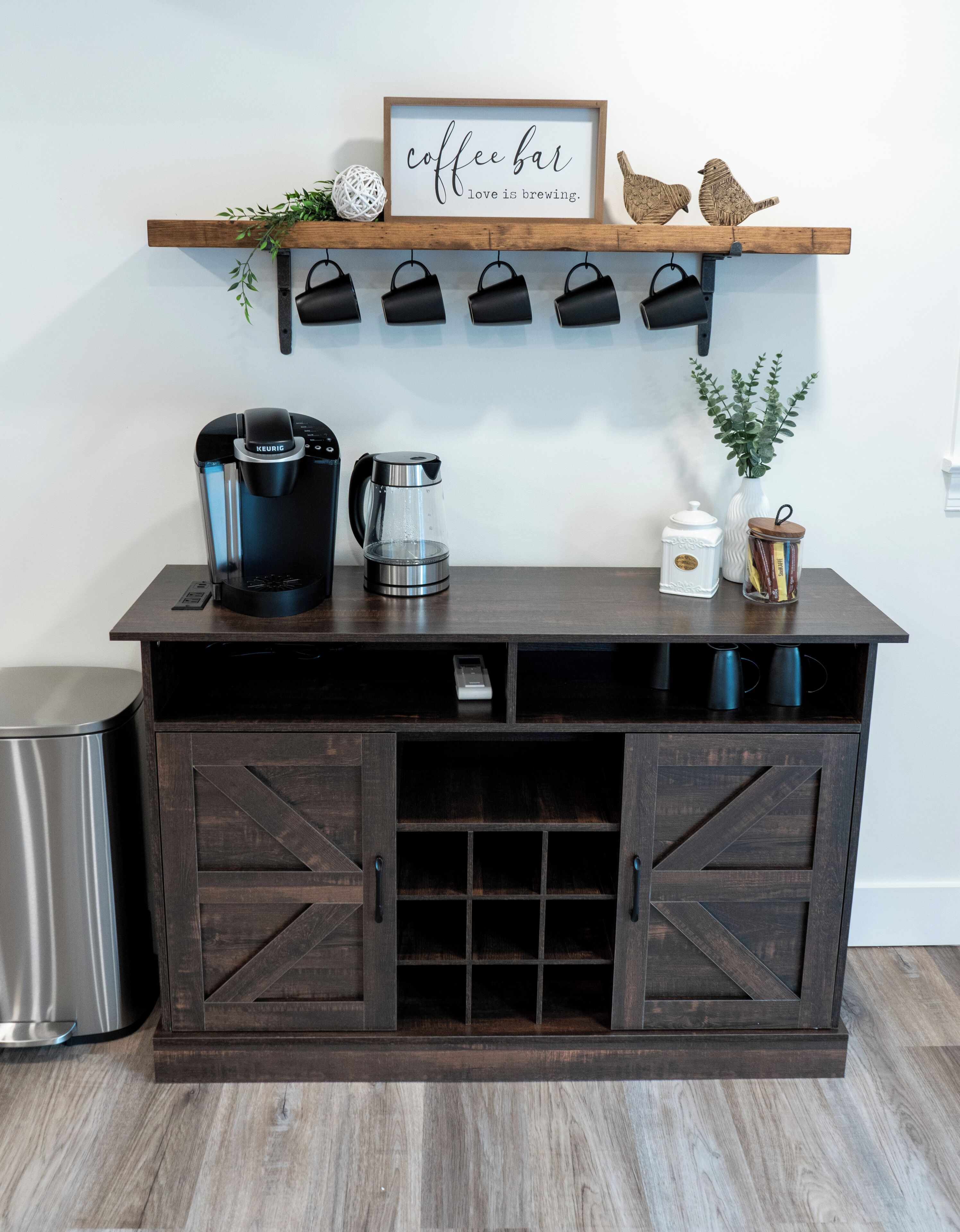 Un coin café équipé d’une machine Keurig, d’une cafetière et d’une bouilloire, le tout posé sur un comptoir en bois.