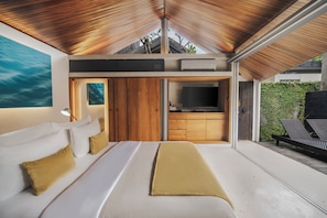 Un dormitorio moderno con una cama grande, un televisor y un techo de madera.