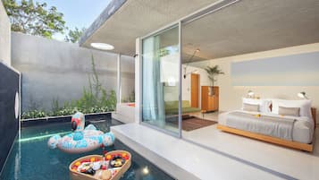 A modern bedroom with a large bed, a glass door leading to a balcony, and a swimming pool with a flamingo float.