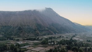 A mountainous landscape with terraced fields and scattered buildings.