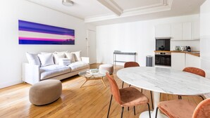 Un salon moderne avec un canapé blanc, une table ronde en marbre et une table basse.