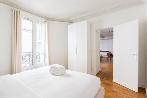 Habitación de hotel con una cama grande, un balcón y vistas a un comedor.
