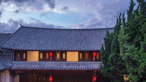 A traditional building with a tiled roof, wooden doors, and red lanterns. - Yahve Academy Hotel (Dali City)