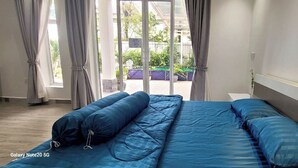 A bedroom with a bed, curtains, and a view of the outdoors. - The Pepperian Homestay (Kampot)