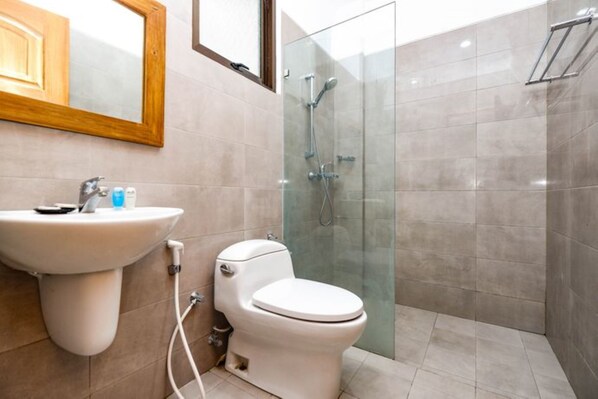 A bathroom with a sink, toilet, and glass-enclosed shower.