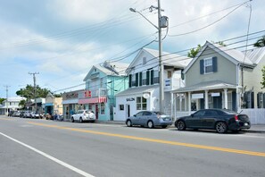 A street lined with buildings, including a salon and a store with a red awning. - Coco`s Poolside Retreat (Key West)