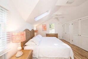 A bedroom with a large bed, a ceiling fan, a window, and a wardrobe. - Coco`s Poolside Retreat (Key West)