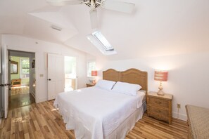 A bedroom with a large bed, a ceiling fan, and a window. - Coco`s Poolside Retreat (Key West)