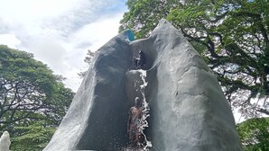 A large rock formation with a water feature cascading down its center. - Backpackers Temple  (Mae Sot)