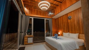 Un dormitorio con paneles de madera, una cama, una mesita de noche y vistas al balcón.