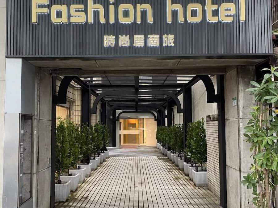 The entrance to a building with a sign reading "Fashion hotel" and Chinese characters.