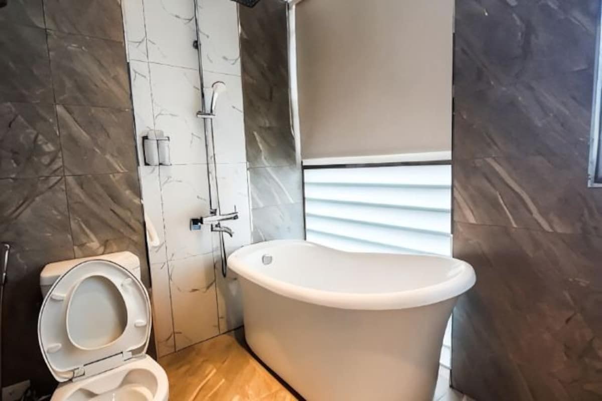 A bathroom with a toilet, a bathtub, and a shower.