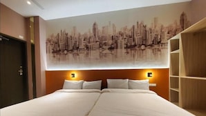 A double bed with a cityscape mural above it, a wooden wardrobe, and a nightstand with a lamp. - Fashion home Hotel (Taipei)