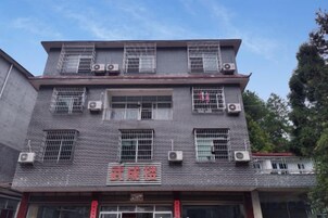 Un edificio de varios pisos con fachada de tejas, numerosas ventanas y unidades de aire acondicionado.