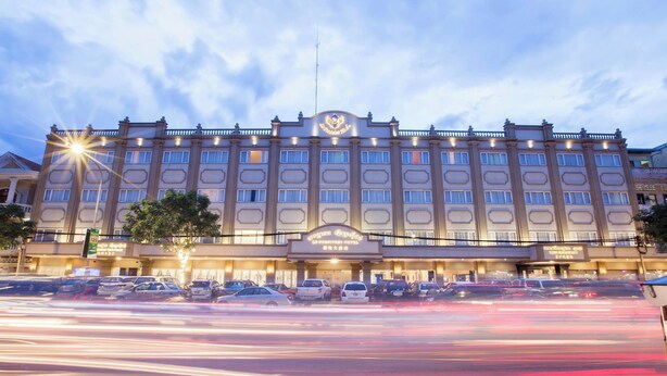 A large, multi-story hotel with a prominent entrance and a sign above the doors. - Le President Hotel  (Phnom Penh)