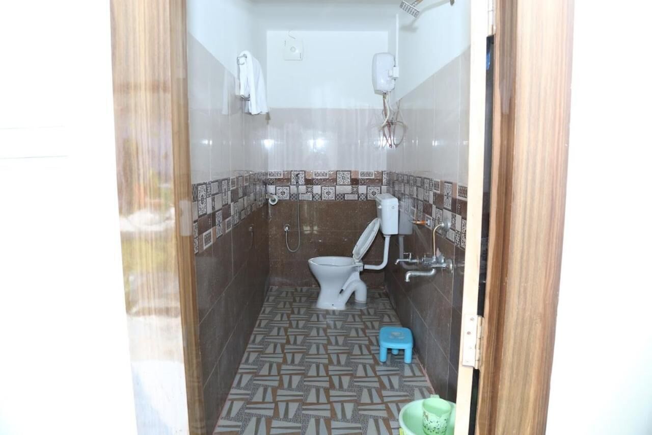 Een kleine badkamer met toilet, bidet en douche.