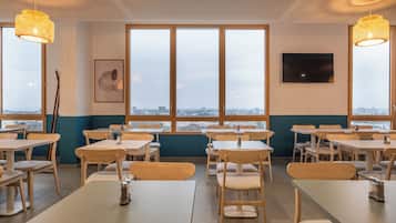 Enjoy meals in this stylish dining area with city views, a flat-screen TV, and pendant lighting.