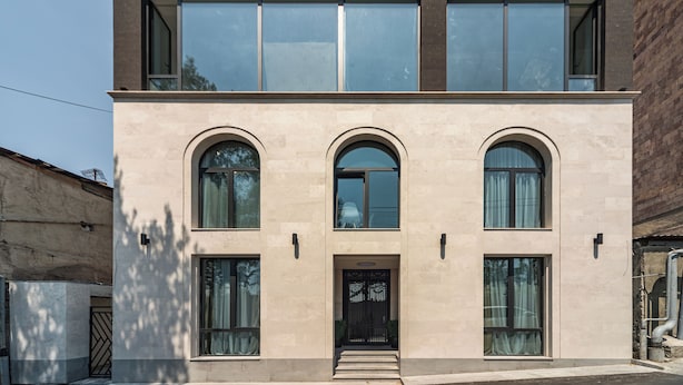 Ein modernes, zweistöckiges Gebäude mit großen Fenstern und einer symmetrischen Fassade.