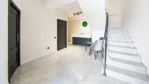 Ein modernes Interieur mit Treppe, Essbereich und Küche.