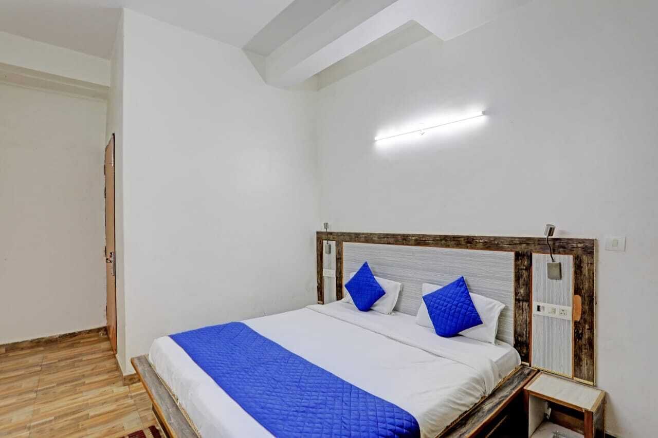 A bedroom with a bed, a nightstand, and a wooden headboard.